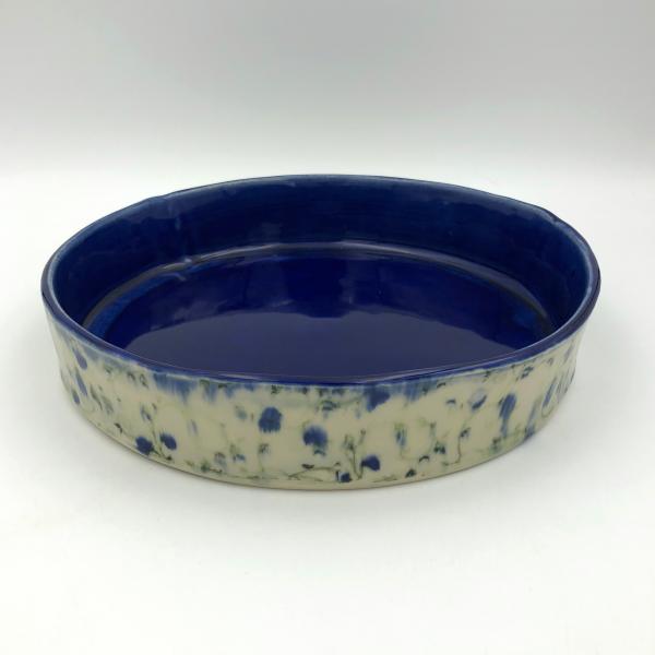 Handbuilt cake pan with rich cobalt glaze inside and blue floral pattern outside. picture