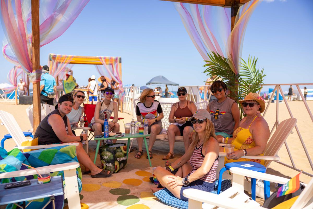 Festival attendees relaxing in a cabana during Pride at the Beach.