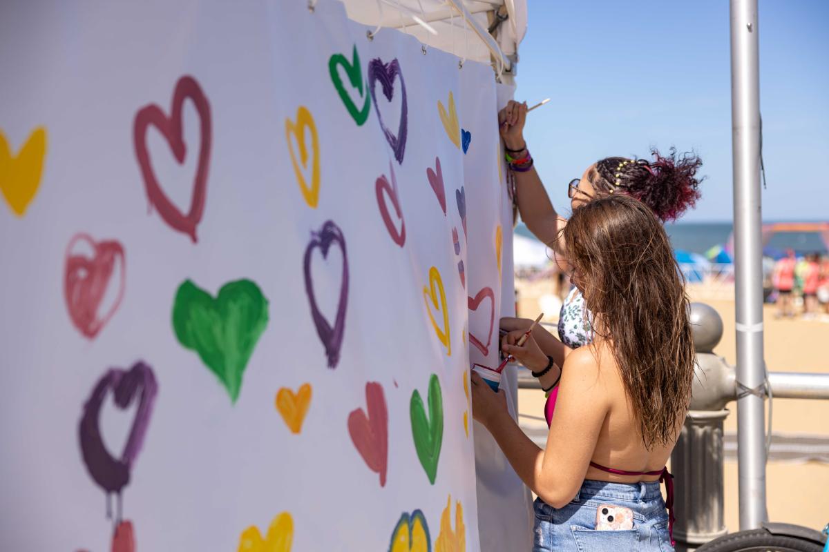 Artist drawing hearts at Pride at the Beach