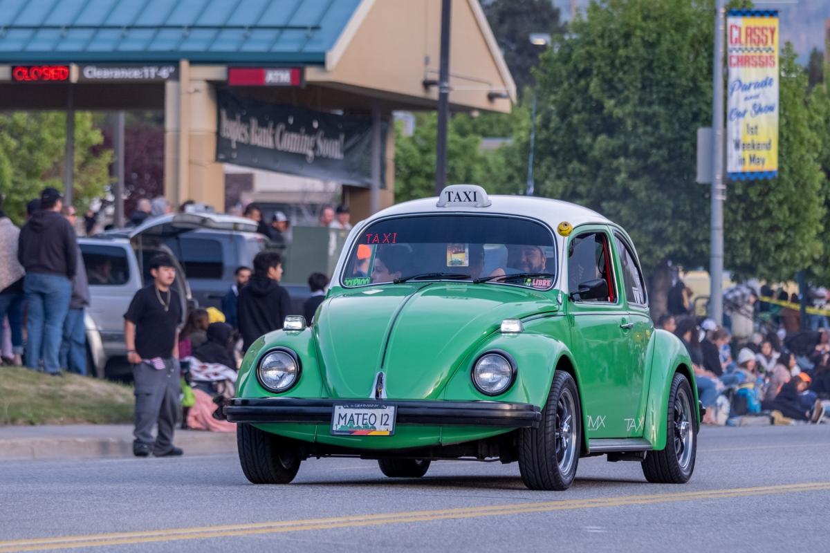 Volkswagon Bug, green body with a white roof and a white taxi sign on top.