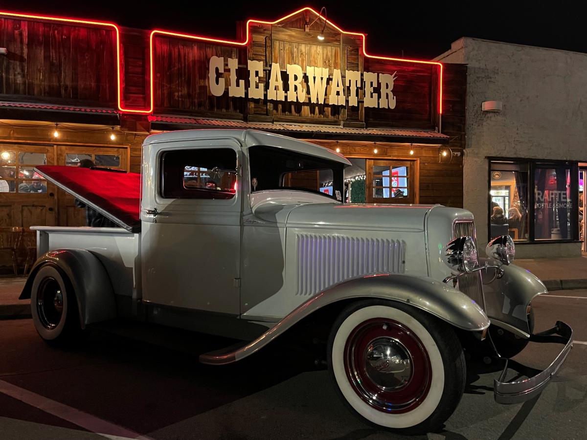 1940's white, pickup truck sitting under the Clearwater Saloon's sign at Dancing in the Streets.