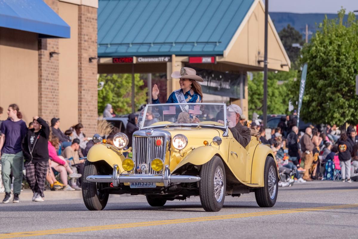 Yellow convertible from the 1940's, carrying the Miss Omak Stampede Queen.
