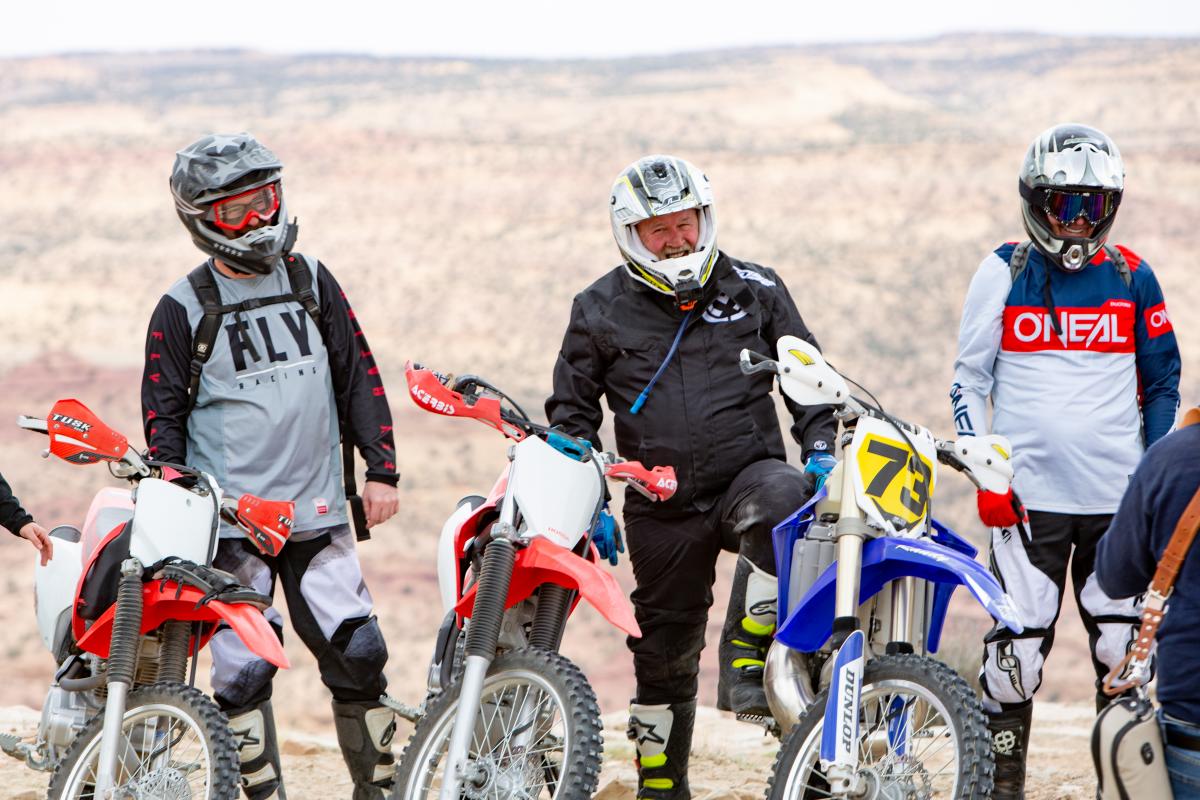 dirt bikers next to their bikes on trail