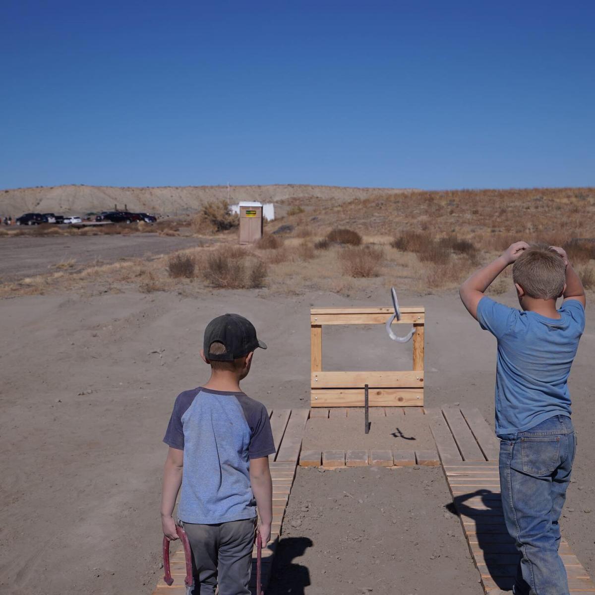 two kiddos throwing horseshoes