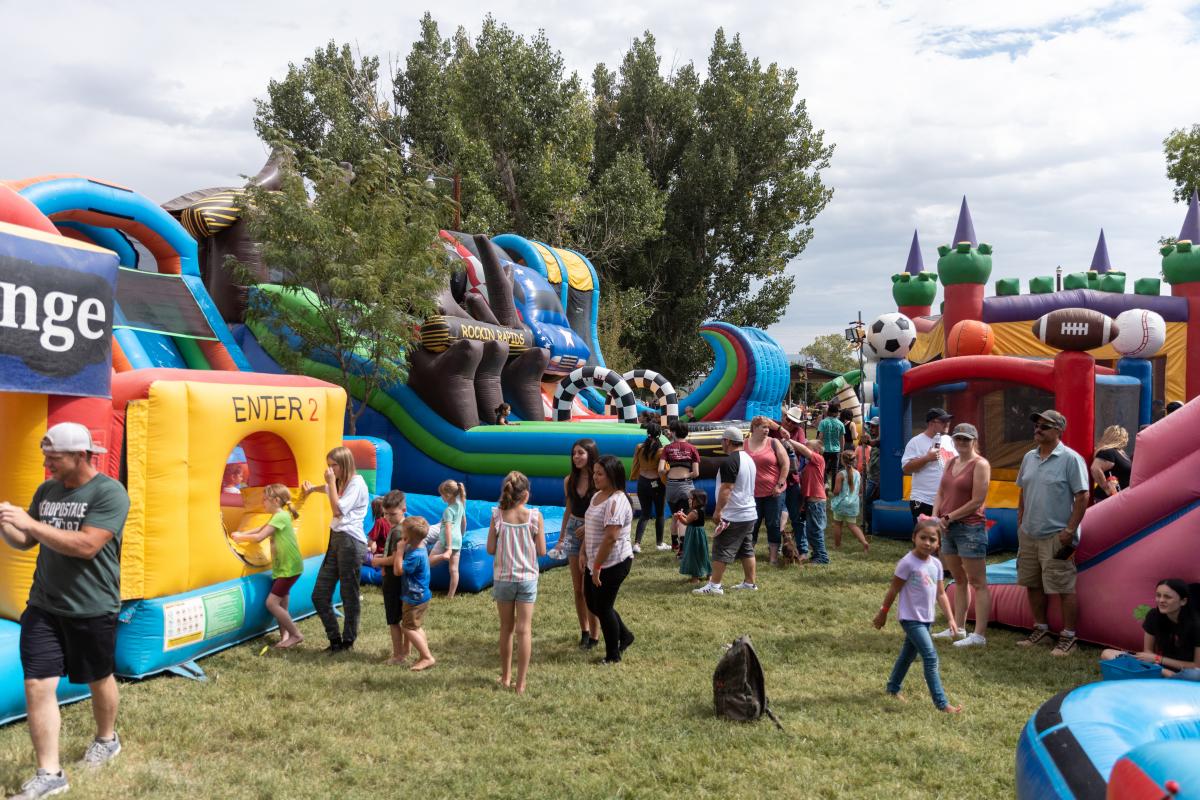 People mingling around Bounce Houses