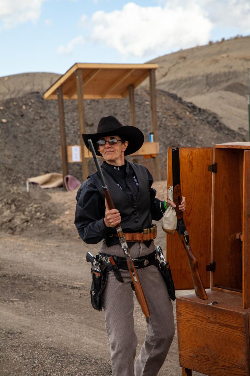 woman carrying two western guns