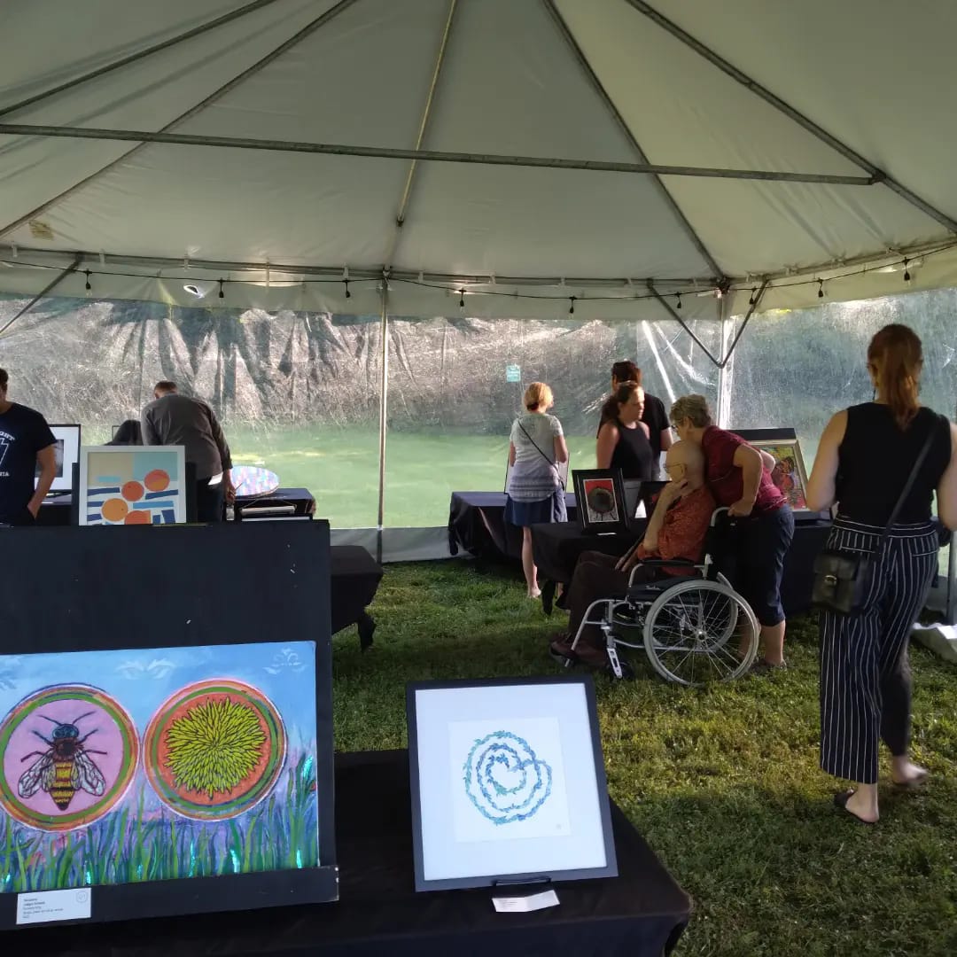 People viewing art in a tent